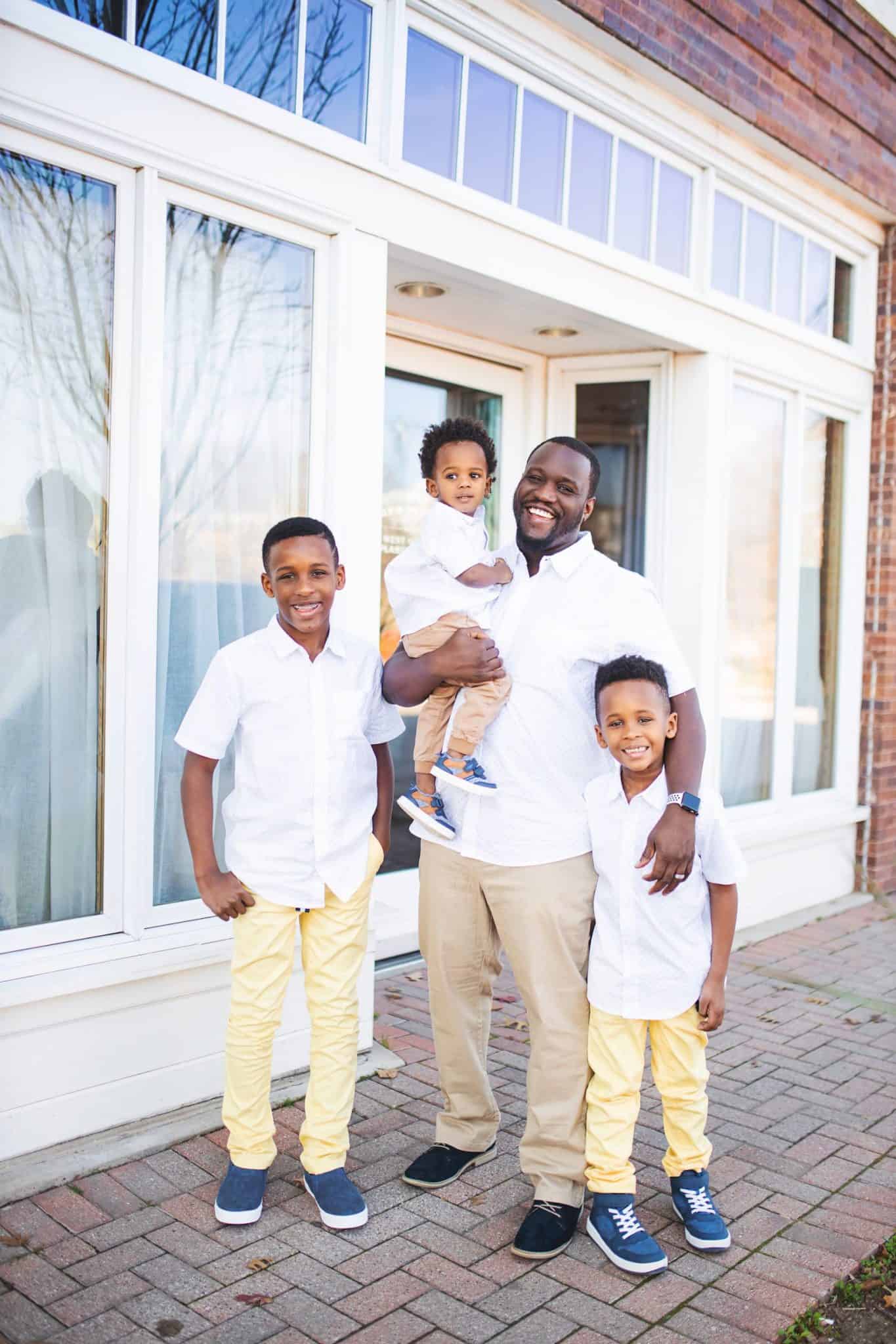 Matching Family Outfits for Spring by popular Dallas fashion blog, Glamorous Versatility: image of a family standing together outside and wearing The Children's Place Baby And Toddler Boys Dad And Me Print Poplin Matching Button Down Shirt, and The Children's Place Baby And Toddler Boys Belted Matching Chino Pants.