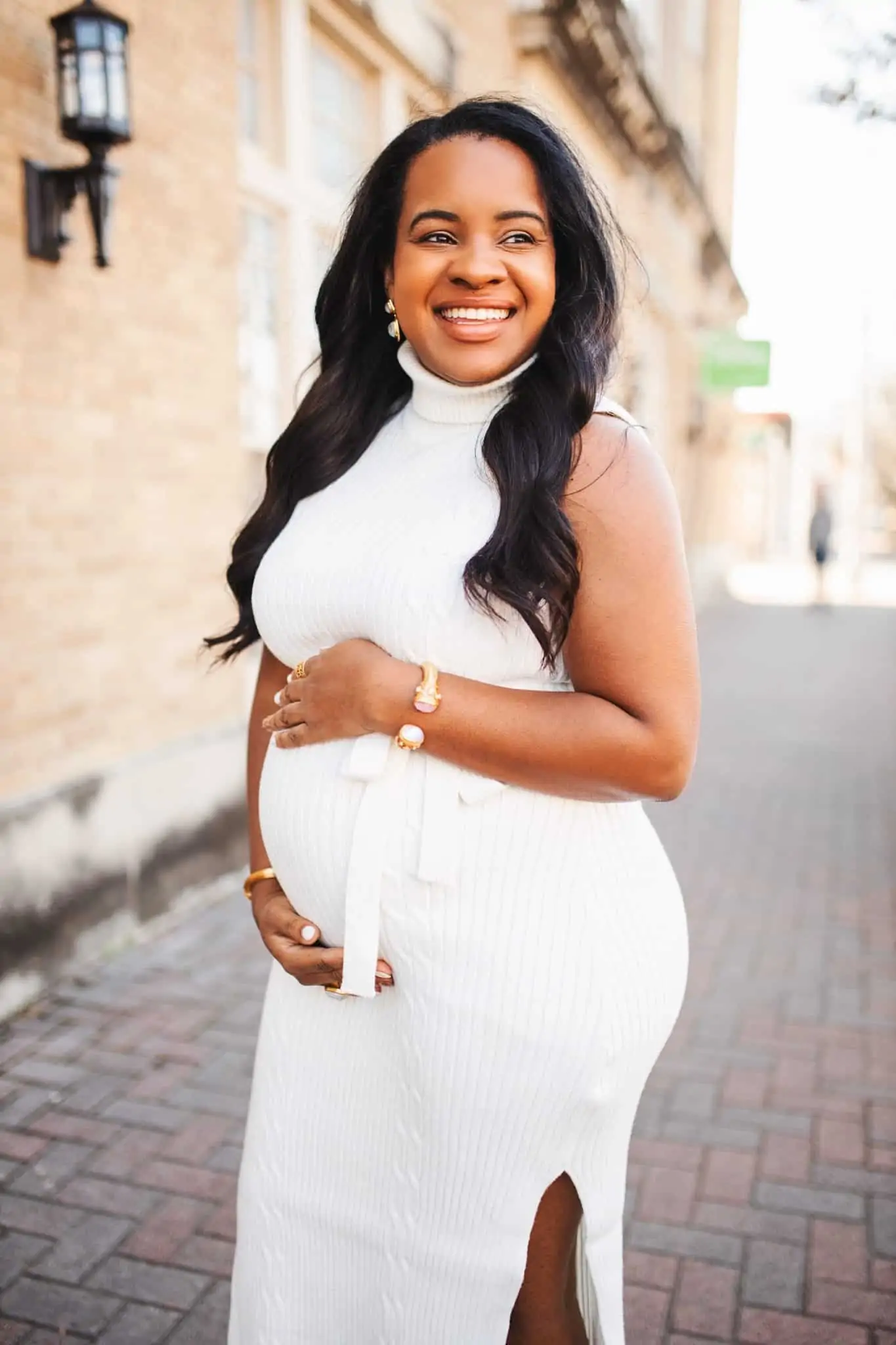 Tips for Moving to Another State by popular Nashville life and style blog, Glamorous Versatility: image of a woman wearing a sleeveless white dress and holding her pregnant belly. 