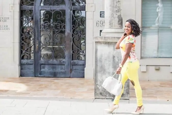 How to Grow Your Blog by popular Dallas lifestyle blog, Glamorous Versatility: image of a woman wearing a multicolor shirt, distressed yellow jeans, nude heels and holding a white purse. 