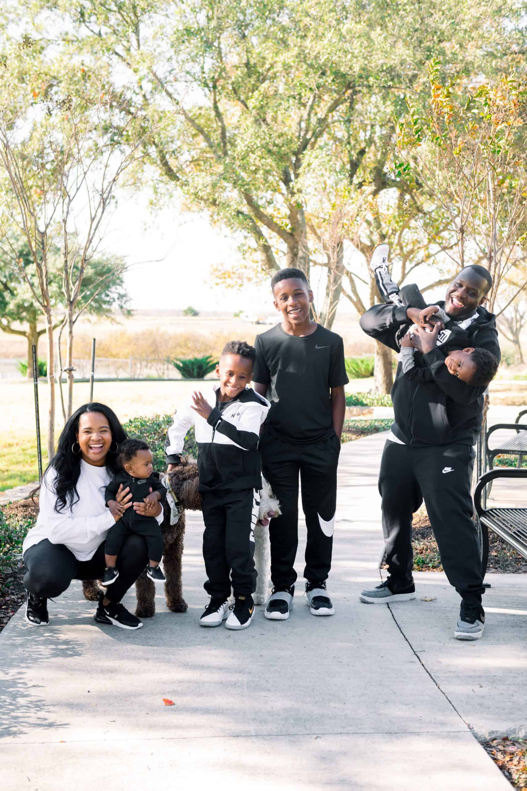 Nike Holiday by popular Dallas fashion blog, Glamorous Versatility: image of family wearing Nike gear and sitting outside at a park with their two dogs. 