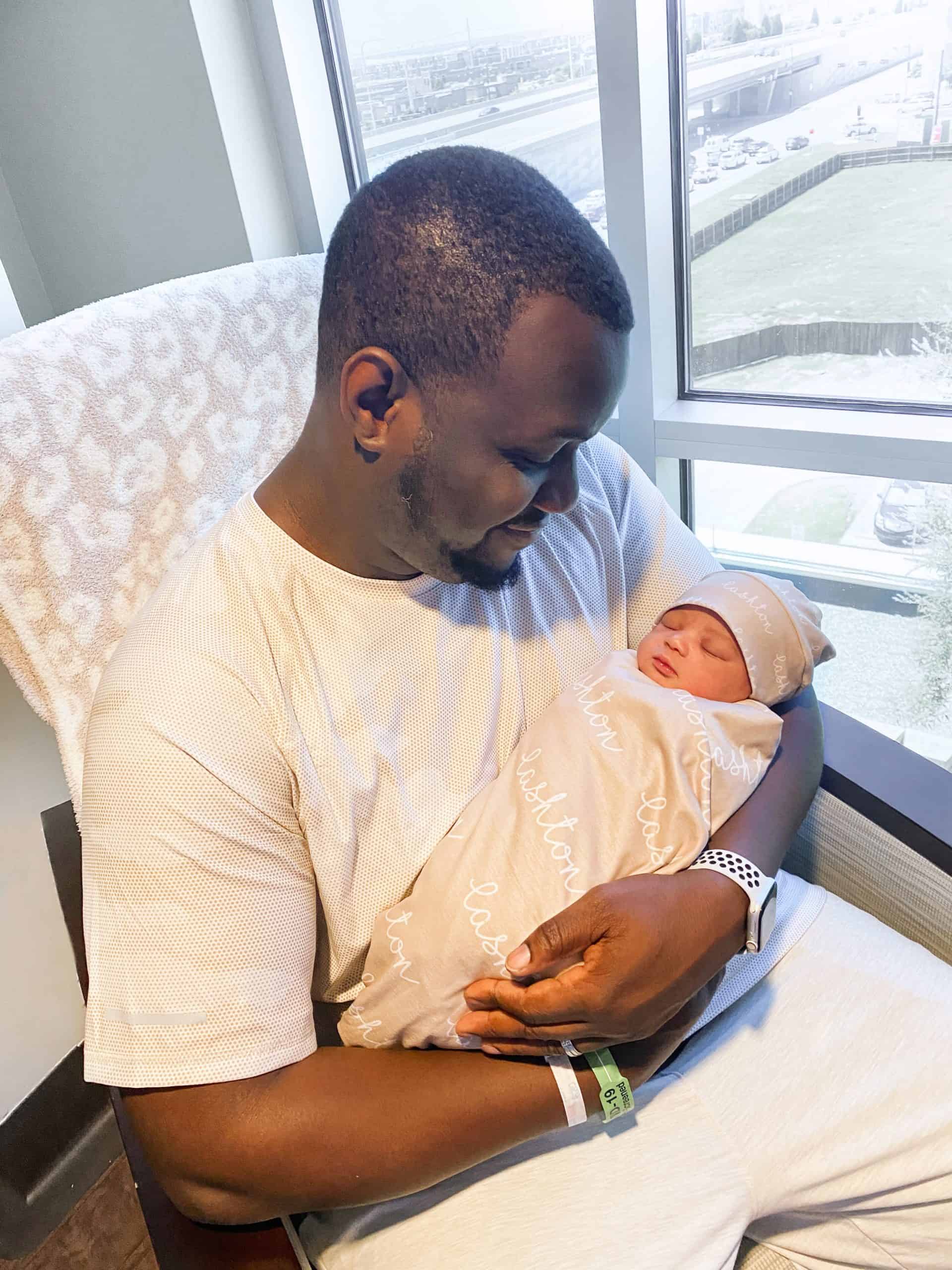 Birth Story by popular Dallas motherhood blog, Glamorous Versatility: image of dad holding his new born baby son. 