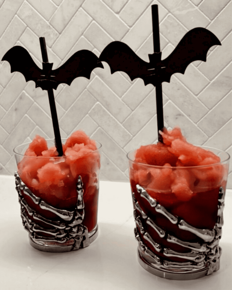 Bloody Pomegranate Margarita in a skeleton hand glass with bat straws. The perfect Halloween cocktail. 